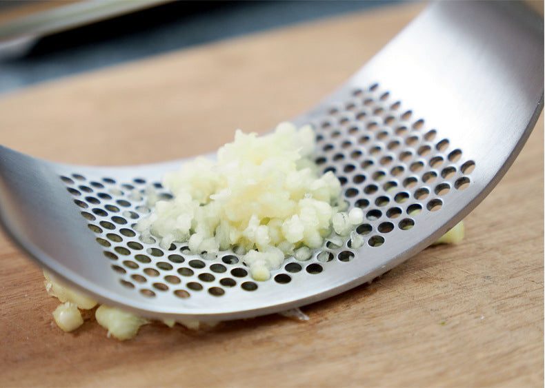 best garlic crusher stainless steel garlic press rocker with finely minced garlic on perforated curved surface