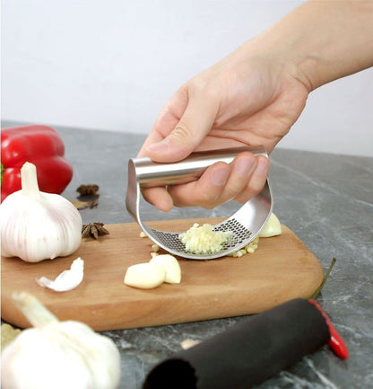 best garlic crusher stainless steel manual garlic press rocker with ergonomic handle crushing garlic cloves on wooden board
