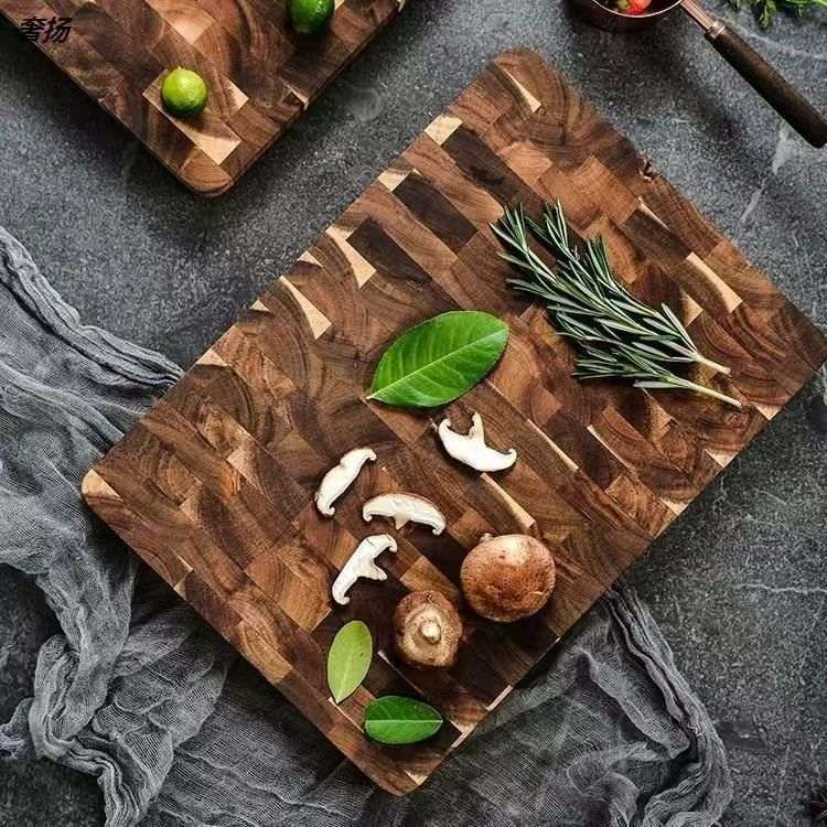 Cutting wood board made of solid acacia mangium wood with a chessboard grid pattern, showing fresh herbs and mushrooms on its surface